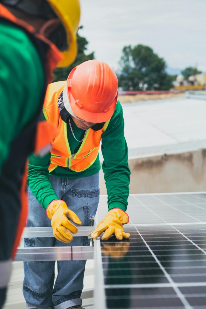pexels-photo-8853507-8853507 Worker in safety gear installing solar panels on a rooftop.