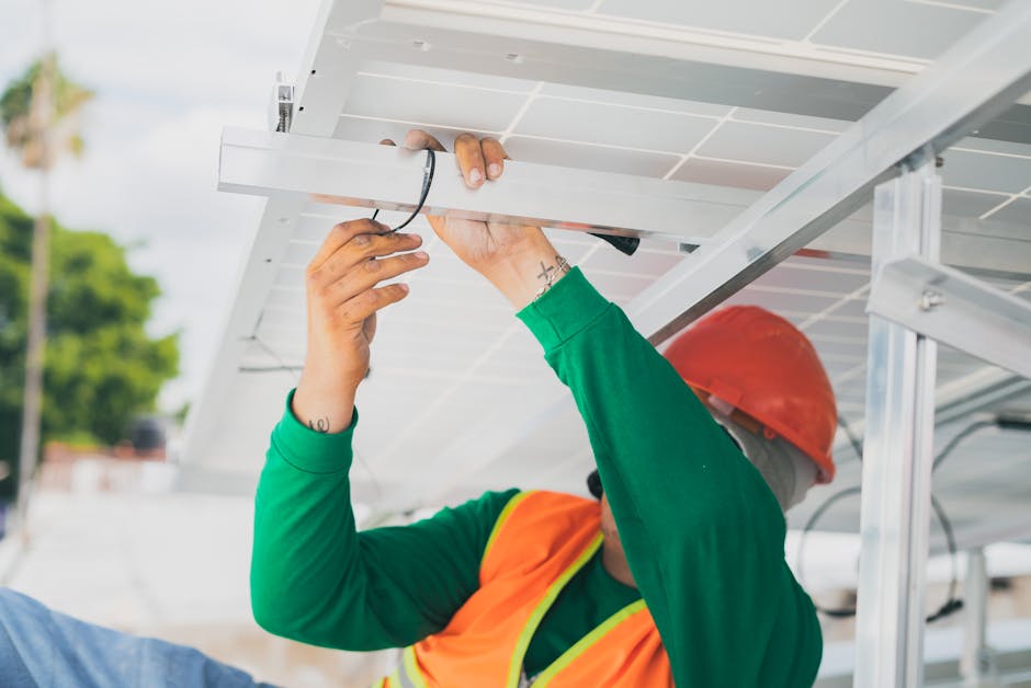 pexels-photo-8853525-8853525-1 A solar technician in PPE installs a solar panel, showcasing renewable energy work.